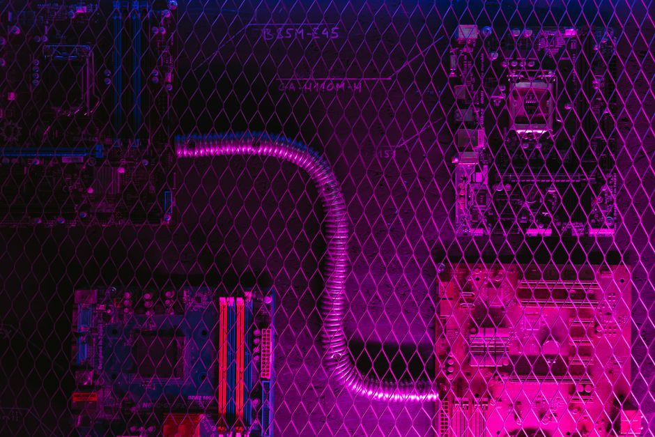 Abstract image of motherboard circuits with a neon glow and diagonal grid overlay, depicting modern technology.
